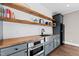 Kitchenette featuring wooden shelves, gray cabinets, stainless steel sink, and appliances at 1636 Sweetwater Ln, Raleigh, NC 27610