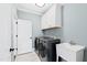 Clean laundry room featuring modern washer and dryer, a utility sink, and storage cabinets at 1636 Sweetwater Ln, Raleigh, NC 27610