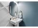 Chic powder room featuring modern pedestal sink, round mirror, and elegant fixtures at 1636 Sweetwater Ln, Raleigh, NC 27610