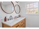 Stylish bathroom featuring dual sinks, a wood vanity, and abundant natural light from a large window at 200 Arlington Cir Cir, Sanford, NC 27330