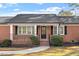 Charming brick home featuring a covered front porch, black shutters and lush landscaping at 200 Arlington Cir Cir, Sanford, NC 27330