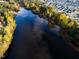 Aerial view of a dark lake surrounded by colorful fall trees and houses at 204 Blue Butterfly Dr, Angier, NC 27501