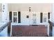 Covered porch with brick flooring and traditional white columns gives this home great curb appeal at 204 N Sixth St, Mebane, NC 27302