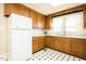 Functional kitchen featuring wood cabinets, white appliances, and black-and-white flooring at 204 N Sixth St, Mebane, NC 27302