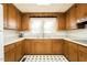 Well-lit kitchen featuring wood cabinets, white countertops, and black-and-white flooring at 204 N Sixth St, Mebane, NC 27302