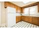 Functional kitchen featuring wood cabinets, white appliances, and black-and-white flooring at 204 N Sixth St, Mebane, NC 27302