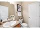 Well-lit bathroom features a single sink vanity, toilet, framed artwork, and a neutral color palette at 206 Whitney Ln, Durham, NC 27713