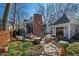 Beautiful backyard featuring a brick fireplace, patio, string lights, and landscaping at 207 Linden Ave, Raleigh, NC 27601
