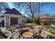 Cozy backyard with an outdoor fireplace, adirondack chairs, and string lights at 207 Linden Ave, Raleigh, NC 27601