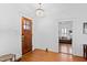 Bright foyer with hardwood floors, complemented by a chandelier and a view into the living room at 207 Linden Ave, Raleigh, NC 27601