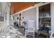 Covered front porch with chairs, porch swing and ceiling fans at 207 Linden Ave, Raleigh, NC 27601
