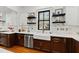 This kitchen features stainless appliances, white cabinets, and decorative shelving by the window at 207 Linden Ave, Raleigh, NC 27601