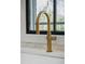 Close-up of a kitchen sink featuring a gold faucet and white subway tile backsplash at 207 Linden Ave, Raleigh, NC 27601