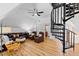 Spacious living room with a black spiral staircase, complemented by warm hardwood floors at 207 Linden Ave, Raleigh, NC 27601