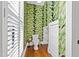 Well-lit powder room featuring tropical wallpaper, white shutters, and a modern toilet at 207 Linden Ave, Raleigh, NC 27601