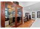 A glass door reveals the wine cellar filled with bottles of wine and a bar cart at 207 Linden Ave, Raleigh, NC 27601