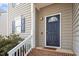 Close-up of a navy blue front door with decorative glass, flanked by white railing and gray siding at 2121 Ramsgate St, Raleigh, NC 27603