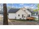 Exterior view of the home showcasing the deck, white siding, and mature trees in the backyard at 214 Linville Ln, Willow Springs, NC 27592