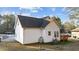The house features white siding, a dark gray roof, a small deck, and mature trees surrounding the property at 214 Linville Ln, Willow Springs, NC 27592