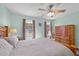 Well-lit main bedroom boasts ample natural light, comfortable bed, and wooden armoire for storage at 214 Linville Ln, Willow Springs, NC 27592
