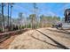 Expansive backyard featuring a gentle slope, mature trees, and a partially visible patio area at 2412 Toll Mill Ct, Raleigh, NC 27606