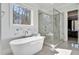 Modern bathroom with a freestanding tub and glass-enclosed shower near a window at 2412 Toll Mill Ct, Raleigh, NC 27606