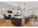 Open-concept living space showcasing the kitchen island with stainless steel appliances and hardwood floors at 2412 Toll Mill Ct, Raleigh, NC 27606