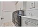 A modern laundry room featuring a gray washer and dryer, stylish sink and cabinetry at 2412 Toll Mill Ct, Raleigh, NC 27606