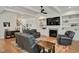 Cozy living room featuring a fireplace, built-in shelving, and three comfortable leather chairs at 2412 Toll Mill Ct, Raleigh, NC 27606