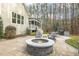 Stone patio with a fire pit, chairs, and mature trees, enhancing outdoor entertainment at 242 Sweet Pine Cir, Pittsboro, NC 27312