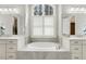 Beautiful bathroom boasting dual sinks, a large tub, and a bright window with plantation shutters at 242 Sweet Pine Cir, Pittsboro, NC 27312