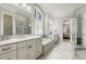 Bright bathroom featuring a double vanity, soaking tub, tiled shower, and large window with plantation shutters at 242 Sweet Pine Cir, Pittsboro, NC 27312
