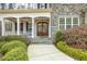 Inviting front entrance with a covered porch, stone accents, and a beautifully landscaped walkway at 242 Sweet Pine Cir, Pittsboro, NC 27312