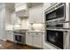 Close up of kitchen with tile backsplash, range, oven, and custom white cabinetry at 242 Sweet Pine Cir, Pittsboro, NC 27312
