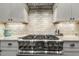 A stainless steel gas range and stone backsplash create a great focal point in the kitchen at 242 Sweet Pine Cir, Pittsboro, NC 27312