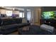 Open-concept living room with a sectional sofa, hardwood floors, and seamless access to the modern kitchen at 2518 Pilot Riley Rd, Zebulon, NC 27597