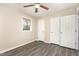 A cozy bedroom featuring neutral walls, a wood-look ceiling fan, and durable gray flooring at 2606 Landis Dr, Durham, NC 27705