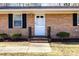 Close-up of the front door and brick facade with a manicured front yard at 2606 Landis Dr, Durham, NC 27705