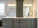 A modern bathroom featuring double sinks, gray cabinets, and a tall central storage cabinet at 2609 Packhouse Rd, Zebulon, NC 27597