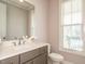 Bathroom featuring a modern vanity, quartz countertop, framed mirror, and natural light from a window at 2609 Packhouse Rd, Zebulon, NC 27597