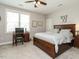 A spacious bedroom with a ceiling fan, hardwood furniture, and a desk at 2609 Packhouse Rd, Zebulon, NC 27597