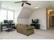 Finished bonus room features carpet, natural light, and a comfortable seating area with TV at 2609 Packhouse Rd, Zebulon, NC 27597