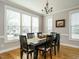 Bright dining room with hardwood floors, large windows, and a traditional chandelier at 2609 Packhouse Rd, Zebulon, NC 27597