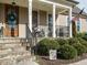 Cozy front porch with rocking chairs, stone steps, and a beautifully decorated wood door at 2609 at 2609 Packhouse Rd, Zebulon, NC 27597