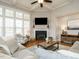 Cozy living room featuring a fireplace, large windows, and comfortable seating arrangement at 2609 Packhouse Rd, Zebulon, NC 27597