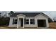 Welcoming single-story home featuring light siding, dark shutters, covered entryway, and convenient garage at 272 Johnson Ridge Way, Four Oaks, NC 27524