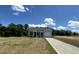 Single-Gathering home featuring gray siding, a black roof, a well-manicured lawn, and a driveway leading to an attached garage at 272 Johnson Ridge Way, Four Oaks, NC 27524