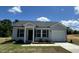 Charming single-Gathering home featuring gray siding, a black roof, a well-manicured lawn, and an attached garage at 272 Johnson Ridge Way, Four Oaks, NC 27524