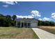 Single-Gathering home featuring gray siding, a black roof, a well-manicured lawn, and a driveway leading to an attached garage at 272 Johnson Ridge Way, Four Oaks, NC 27524