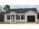 Inviting single-story home with light siding, dark shutters, covered entryway and attached garage at 272 Johnson Ridge Way, Four Oaks, NC 27524